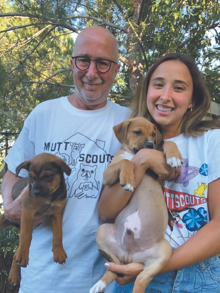 Victoria and her dad, Paul Shaffer, standing outside,, each with a pup in their hands - Love, Dog